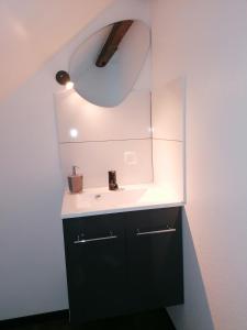 a bathroom with a sink and a mirror at Ferienwohnung IV Sarrebriese in Bottmersdorf