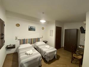 um quarto de hotel com duas camas e uma televisão em B&b Boladina Experience em Baunei