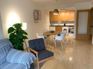 a living room and kitchen with a table and chairs at Acogedor apartamento con piscina en Vilafortuny, Cambrils in Cambrils