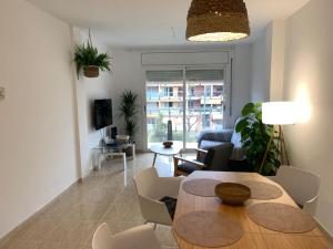 uma sala de estar com uma mesa e cadeiras e um sofá em Acogedor apartamento con piscina en Vilafortuny, Cambrils em Cambrils