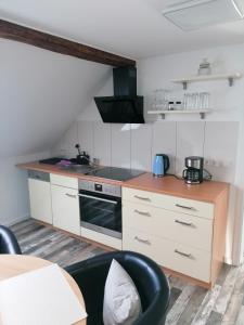 a small kitchen with a stove and a sink at Ferienwohnung III Sarrebriese in Bottmersdorf +19 photos