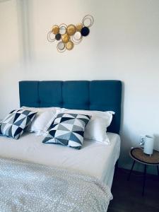 a bed with a blue headboard and pillows on it at Apartments Angelo in Bibinje