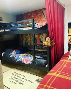 - une chambre avec des lits superposés et un ours en peluche au sol dans l'établissement Les sorciers, la Diligence St Jean de Losne, à Saint-Jean-de-Losne
