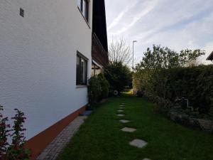 a yard next to a white building with a pathway at Beautiful 3 rooms apartment 110 m2, kostenloser Parkplatz, großer Balkon in Heßdorf