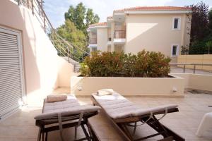 ein Paar Stühle auf einer Terrasse in der Unterkunft Aelia luxury apartment with private entrance in Karavomylos