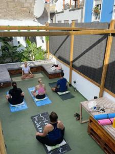 een groep mensen die op de vloer yoga doen bij Compass House in Las Palmas de Gran Canaria