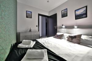 a bedroom with a large bed with two towels on it at Apartament 33 Lake & View Centralny Widok na Jezioro -100 metrów od Jeziora Czorsztyńskiego i ścieżki rowerowej Velo Czorsztyn in Kluszkowce
