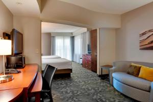 a hotel room with a bed and a desk and a couch at Courtyard Statesville Mooresville/Lake Norman in Statesville