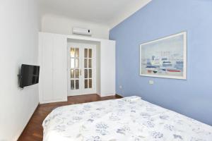 a blue bedroom with a bed and a tv at A Casa di Sara in Florence