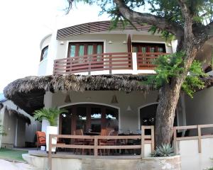 a house with a tree in front of it at Hotel Sao Francisco in Jericoacoara