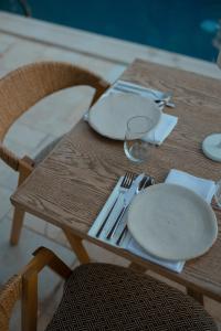 a wooden table with plates and utensils on it at Anthemion Suites and Villas in Nafplio