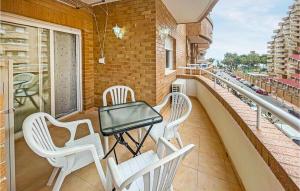 balkon z białymi krzesłami i stołem. w obiekcie 2 Bedroom Cozy Apartment In Oropesa w mieście Oropesa del Mar