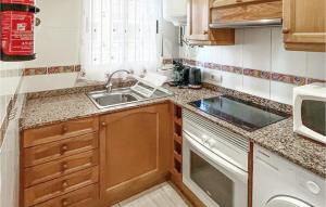 mała kuchnia ze zlewem i kuchenką mikrofalową w obiekcie 2 Bedroom Cozy Apartment In Oropesa w mieście Oropesa del Mar