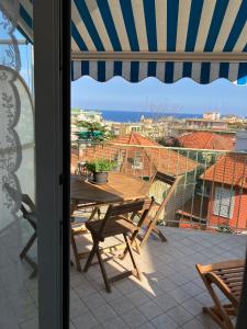een patio met een tafel en stoelen op een balkon bij Aria di mare in Sanremo