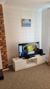 a living room with a large flat screen tv at RTM COMFORTABLE Home in Basildon
