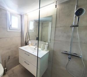 bagno con doccia, lavandino e specchio di nona's a Salonicco