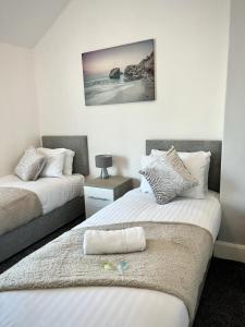 a bedroom with two beds and a nightstand with a picture at Thorpe Place in Hawthorn