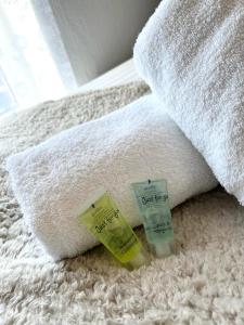 a towel and two bottles of soap on a bed at Thorpe Place in Hawthorn