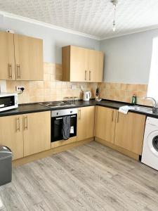 a kitchen with wooden cabinets and a washer and dryer at Thorpe Place in Hawthorn