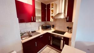 a kitchen with brown cabinets and a sink and a microwave at Messewohnung Düsseldorf/Essen in Ratingen
