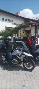 duas pessoas em motocicletas estacionadas em frente a uma loja em Ipekyolu Garden em Avanos