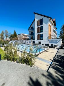 a building with a swimming pool in front of a building at Apartamenty Dolce Vita in Ostrowo