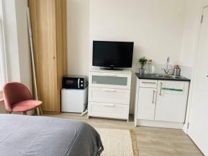 a bedroom with a bed and a television on a dresser at Studio close to Camden in London