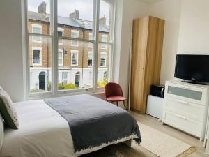 倫敦的住宿－Studio close to Camden，一间卧室设有一张床和一个大窗户