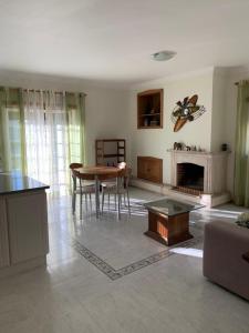 a living room with a table and a fireplace at Casa 28 in Pataias