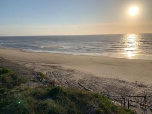 a beach with the sun rising over the ocean at Casa 28 in Pataias