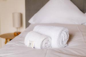 una pila de toallas sentadas encima de una cama en Servus Apartments Neuhaus am Inn en Neuhaus am Inn