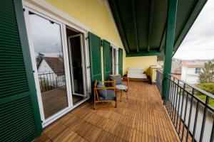 un balcón de una casa con paredes verdes y amarillas en Servus Apartments Neuhaus am Inn en Neuhaus am Inn