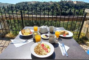 una mesa con platos de desayuno y zumo de naranja en Best Relax in the best part of Gozo your own bedroom with Ensuite Toilet and Shared Pool Bed and Breakfast en Għajn il-Kbira