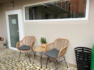 3 chaises et une table sur une terrasse dans l'établissement 2 Zi-Apartment Fauser Echterdingen-Messe, à Leinfelden-Echterdingen