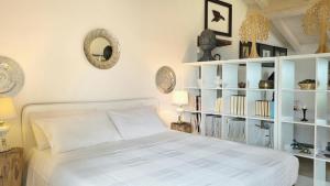 una camera con un letto bianco e una libreria di Agriturismo Podere Le Palaie a Monterotondo