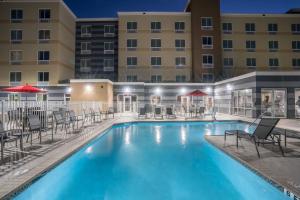 una piscina con sillas y un hotel en Fairfield Inn & Suites by Marriott Gainesville I-75, en Gainesville
