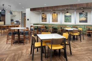 a restaurant with tables and chairs and a bar at Fairfield Inn & Suites by Marriott Gainesville I-75 in Gainesville