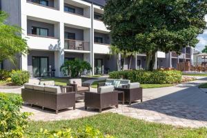 eine Reihe von Stühlen und Tischen vor einem Gebäude in der Unterkunft Courtyard by Marriott Orlando Airport in Orlando