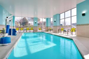 a large swimming pool with blue water in a building at SpringHill Suites by Marriott Salt Lake City Sugar House in Salt Lake City