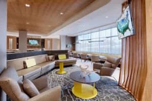 a lobby with a couch and chairs and a table at SpringHill Suites by Marriott Salt Lake City Sugar House in Salt Lake City