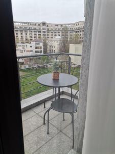 einen Tisch und Stühle auf einem Balkon mit Blick auf ein Gebäude in der Unterkunft Unirii Apartament 2 in Bukarest