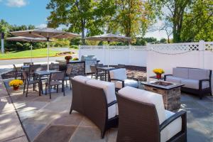 eine Terrasse mit Tischen, Stühlen und Sonnenschirmen in der Unterkunft Residence Inn Cherry Hill Philadelphia in Cherry Hill