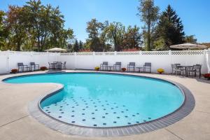 einen Pool mit Stühlen und einem weißen Zaun in der Unterkunft Residence Inn Cherry Hill Philadelphia in Cherry Hill