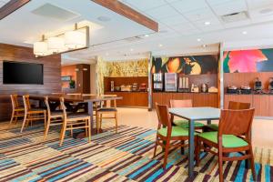 a dining room with a table and chairs and a tv at Fairfield Inn & Suites by Marriott Decatur at Decatur Conference Center in Decatur