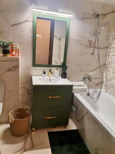 ein Badezimmer mit einem Waschbecken, einem Spiegel und einer Badewanne in der Unterkunft Unirii Apartament 2 in Bukarest