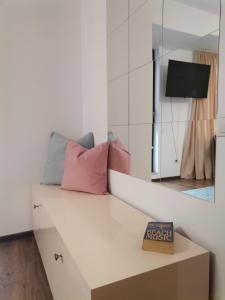 ein Zimmer mit einer Bank mit zwei Kissen und einem Buch in der Unterkunft Unirii Apartament 2 in Bukarest