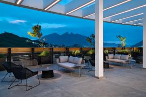 a patio with furniture and a view of mountains at AC Hotel by Marriott Monterrey Valle in Monterrey