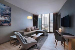 a living room with a couch and a television in a room at AC Hotel by Marriott Monterrey Valle in Monterrey