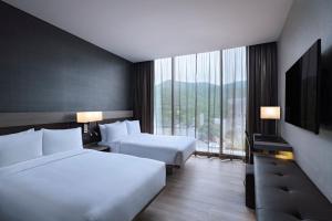 a hotel room with two beds and a large window at AC Hotel by Marriott Monterrey Valle in Monterrey