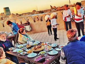 a group of people sitting around a table eating food at HOTEL KALA KHIVA in Khiva